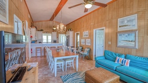 A spacious kitchen with wooden walls, a dining area with white chairs, a blue sofa, and a ceiling fan. - Ocean Breeze - Near Ocean, 5 Bedrooms, Litchfield (Litchfield)
