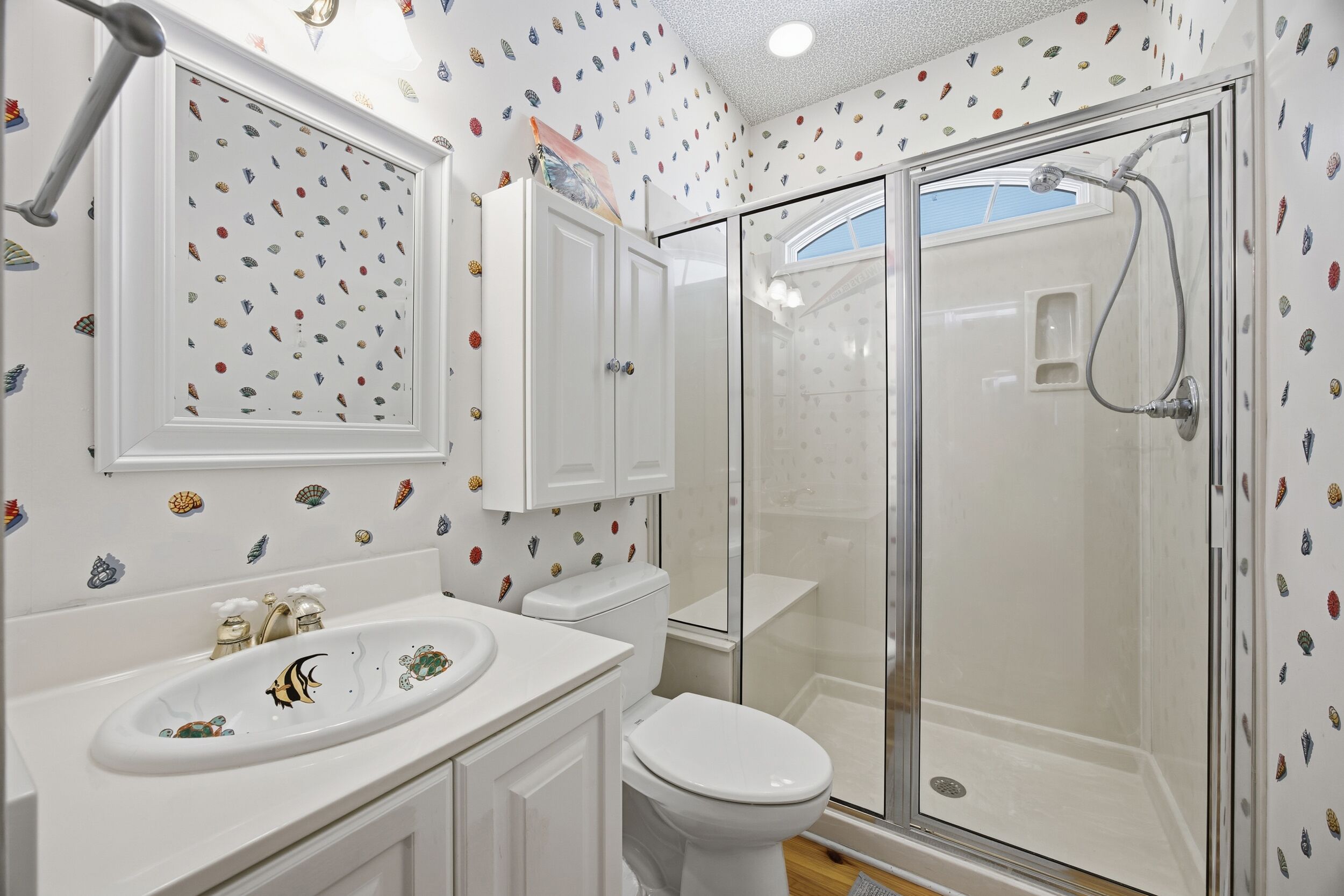 A bathroom with a shower, toilet, and sink.