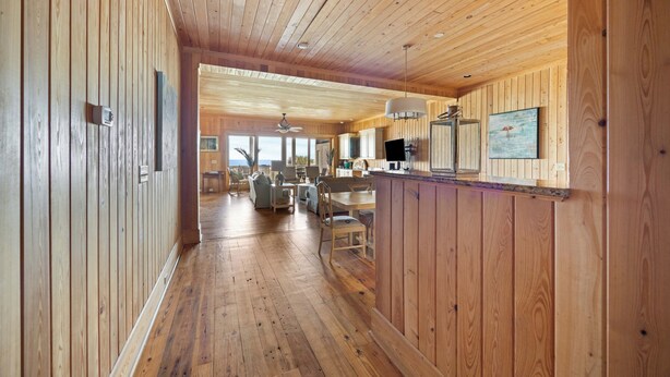 A wooden interior with a long hallway leading to a dining area.