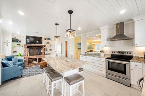 Eine moderne Küche mit einer Mittelinsel, Backofen und Kamin.