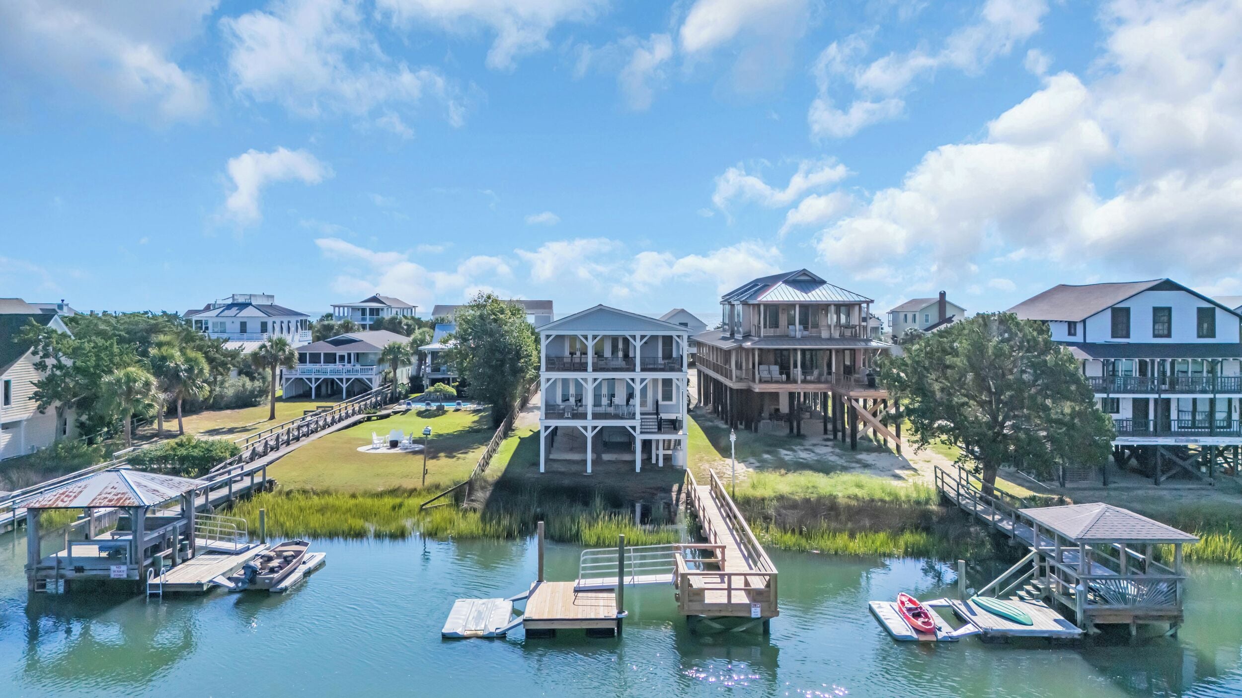 A waterfront property with multiple buildings, docks, and a grassy area with a fountain.