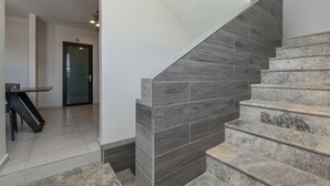 Una escalera de piedra gris con escalones y paredes que lleva a una puerta con el número 6.