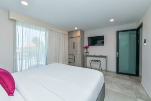 A hotel room with a bed, a desk, a TV, and a sliding door. - Rooftop Pool w/Lounge Area-1BE1BA Sleeps 2 #A6 (Oranjestad)