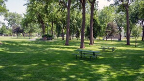A park with green grass, trees, and picnic tables. - Historic Mc Kennan Park Apt 5 (1 bed 1 bath) - KP220APT5 (Sioux Falls)
