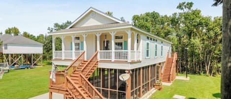 A two-story house with a covered porch and a wooden staircase.