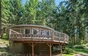 A wooden cabin with a glass enclosure, surrounded by a forest. - TreeTops Forest Retreat (Lopez Island)