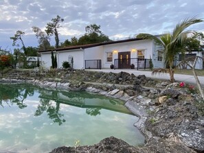 Ein Haus mit Swimmingpool, umgeben von Felsen und Bäumen.