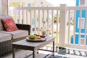 A wooden table with a fruit platter and wine glasses on a porch with a white railing. - 2 Min Walk to Beach | Summer Paradise| Sleeps 6 (Atlantic Beach)