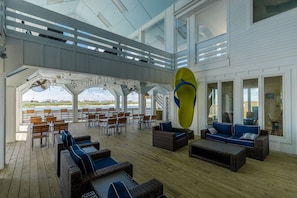 A covered outdoor seating area with wicker furniture and a large yellow decorative piece. - Casa Sea-Esta at Aruba Bay Resort (Corpus Christi)