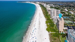 An aerial view of a coastal city with a long sandy beach lined with high-rise hotels. - Family Friendly Condo @ SeaWinds, Remodeled Aveline, On🏖,  2 King EnSuites, Pool (Marco Island)