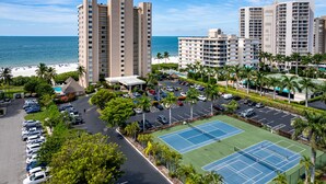 A high-rise hotel with a tennis court and parking lot, overlooking a beach. - Family Friendly Condo @ SeaWinds, Remodeled Aveline, On🏖,  2 King EnSuites, Pool (Marco Island)