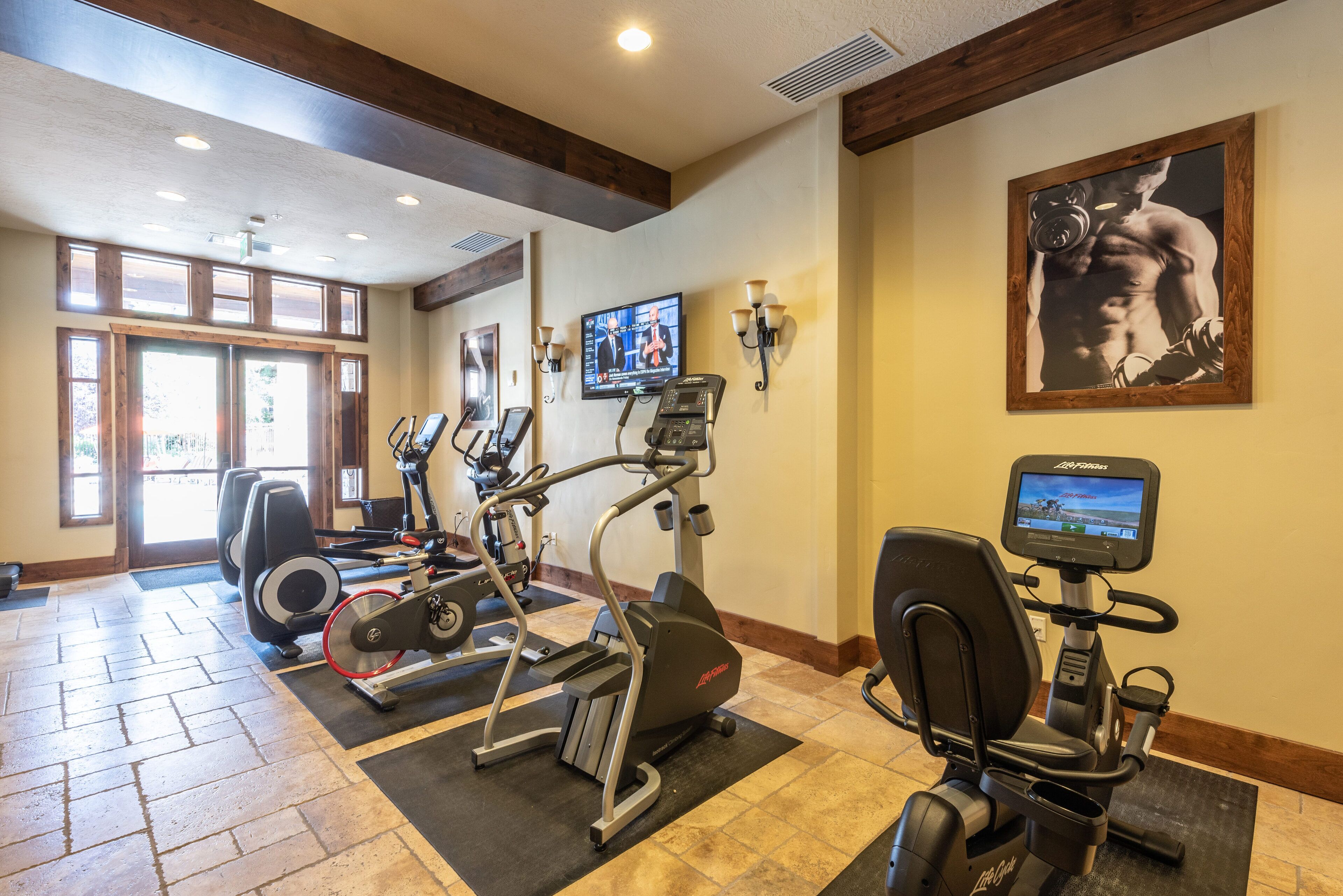 A gym with treadmills, elliptical machines, and weight benches.