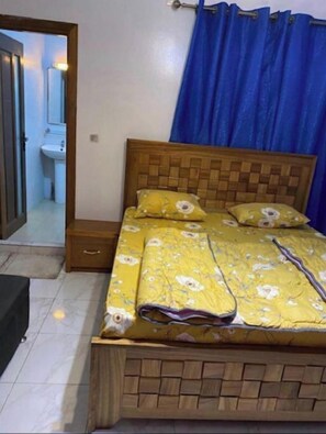 Cozy retreat with a comfortable bed, wooden headboard, and a nightstand.