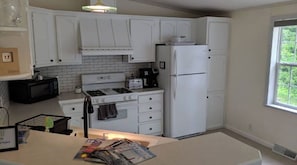 Effortlessly prepare meals in this well-equipped kitchen with a stove, microwave, and refrigerator.