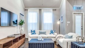 Ein Wohnzimmer mit einer Couch, einem Couchtisch und einem Fernseher.