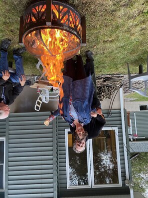 A fire pit with a metal grill and a person hanging upside down above it. - “Loft like Condo in the sky above Lincoln Center” (New York)