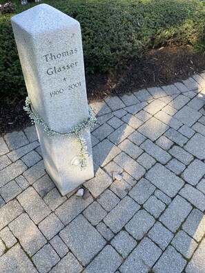 A gravestone with the name "Thomas Glasser" and the years "1960-2001" engraved on it. - “Loft like Condo in the sky above Lincoln Center” (New York)