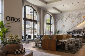 A restaurant interior with a bar, seating, and a sign reading 'OTTO'S UPTOWN KITCHEN'.