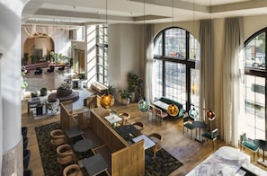 A spacious lobby with a seating area, a bar, and large windows.