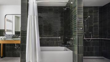 Een moderne badkamer met een bad, douche en een wastafel met spiegel.