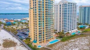 A high-rise hotel with multiple floors, a pool, and a beach view. - 🌅 INCREDIBLE View ~ Free Beach Service..SPACIOUS-Remodeled Kitchen~Gulf Front 🏖️ (Navarre)