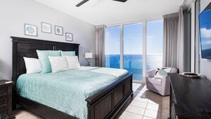 A bedroom with a large bed, a nightstand, a chair, a desk, and a view of the ocean. - 🌅 INCREDIBLE View ~ Free Beach Service..SPACIOUS-Remodeled Kitchen~Gulf Front 🏖️ (Navarre)