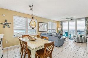 Un salón espacioso con una mesa de comedor, un sofá y un balcón con vistas.