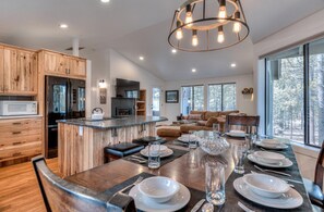Relax in this open-plan living space with a kitchen island, dining area, and cozy fireplace.