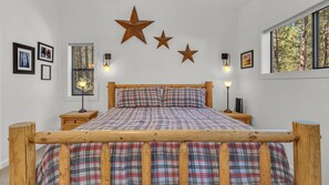 Relax in this serene bedroom with a comfortable bed, large window, and charming decor.