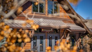 A wooden building with a sign reading "Sunriver Brewing." There are outdoor tables and chairs in front. - Abbot House Condo 8 (Bend)