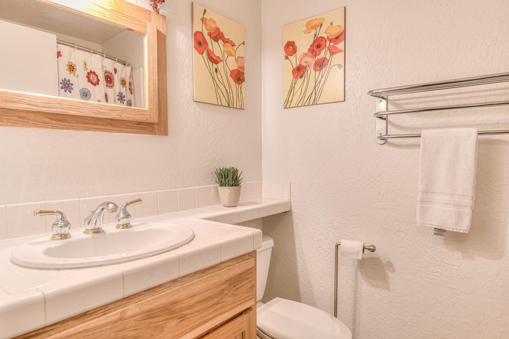 A bathroom with two sinks, a mirror, a toilet, and a towel rack.