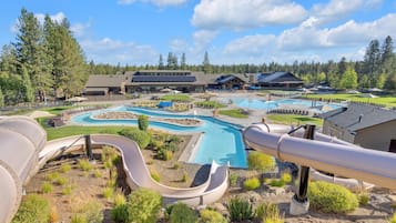 Un resort con varias piscinas, un tobogán de agua y un edificio grande de diseño moderno.