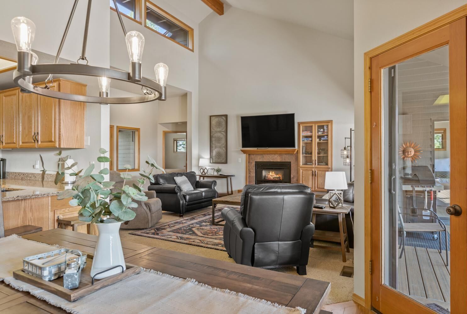 Amplia sala de estar con chimenea, muebles de cuero y un televisor grande.