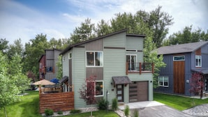 A modern two-story house with a covered patio, a garage, and a well-maintained lawn. - Bozeman/4Corners HomeBase • River Access & Fire Pit • Close to Skiing and Hiking (Bozeman)
