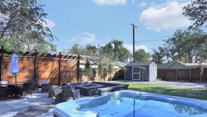 A backyard with a hot tub, outdoor furniture, and a wooden fence. - Cheerful Lake House minutes from all Colorado Springs has to offer! (Colorado Springs)