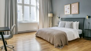 Un dormitorio moderno con una cama grande, un escritorio y una silla.