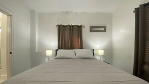 A neatly made bed with a headboard, two bedside lamps, and a window with curtains. - 5 ★ 5min → Downtown/Shopping ★ Smart TVs ★ Balcony (Grand Rapids)