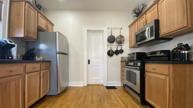 A kitchen with wooden cabinets, a stainless steel refrigerator, a microwave, and a stove. - 5 ★ 5min → Downtown/Shopping ★ Smart TVs ★ Balcony (Grand Rapids)