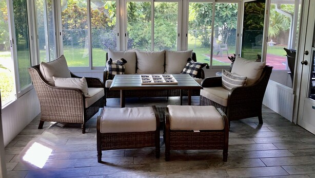 A sunroom with wicker furniture, a ceiling fan, and large windows overlooking a garden. - 🌴Tropical Retreat in Sarasota  (Sarasota)