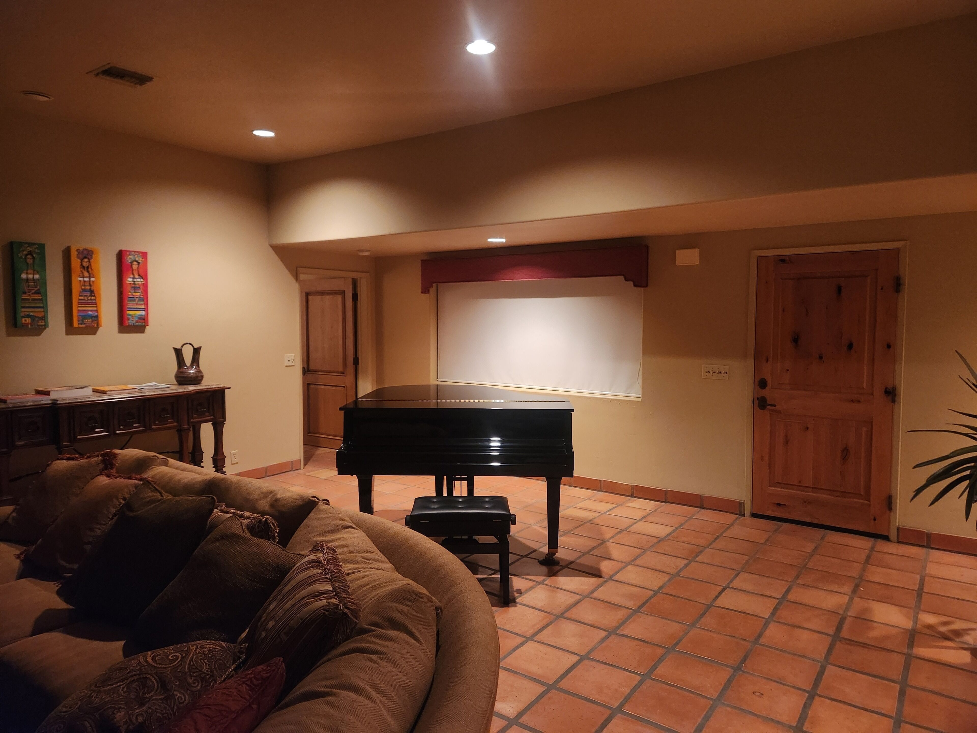 Un salon avec un piano, un canapé et une porte.