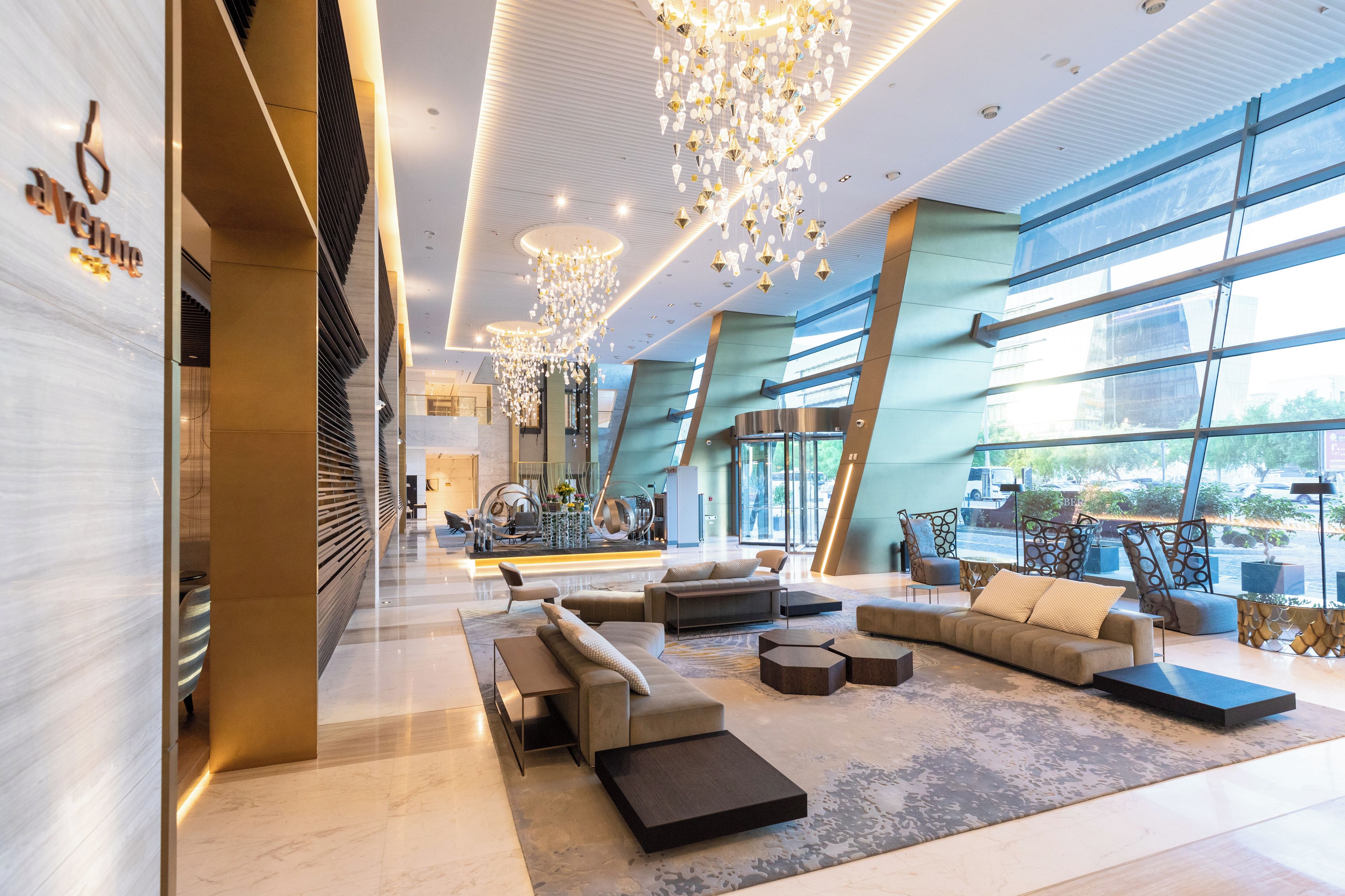 Un vestíbulo amplio con muebles modernos, ventanas grandes e iluminación decorativa.