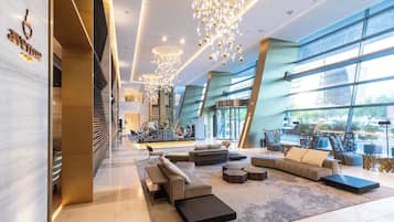 Un vestíbulo amplio con muebles modernos, ventanas grandes e iluminación decorativa.