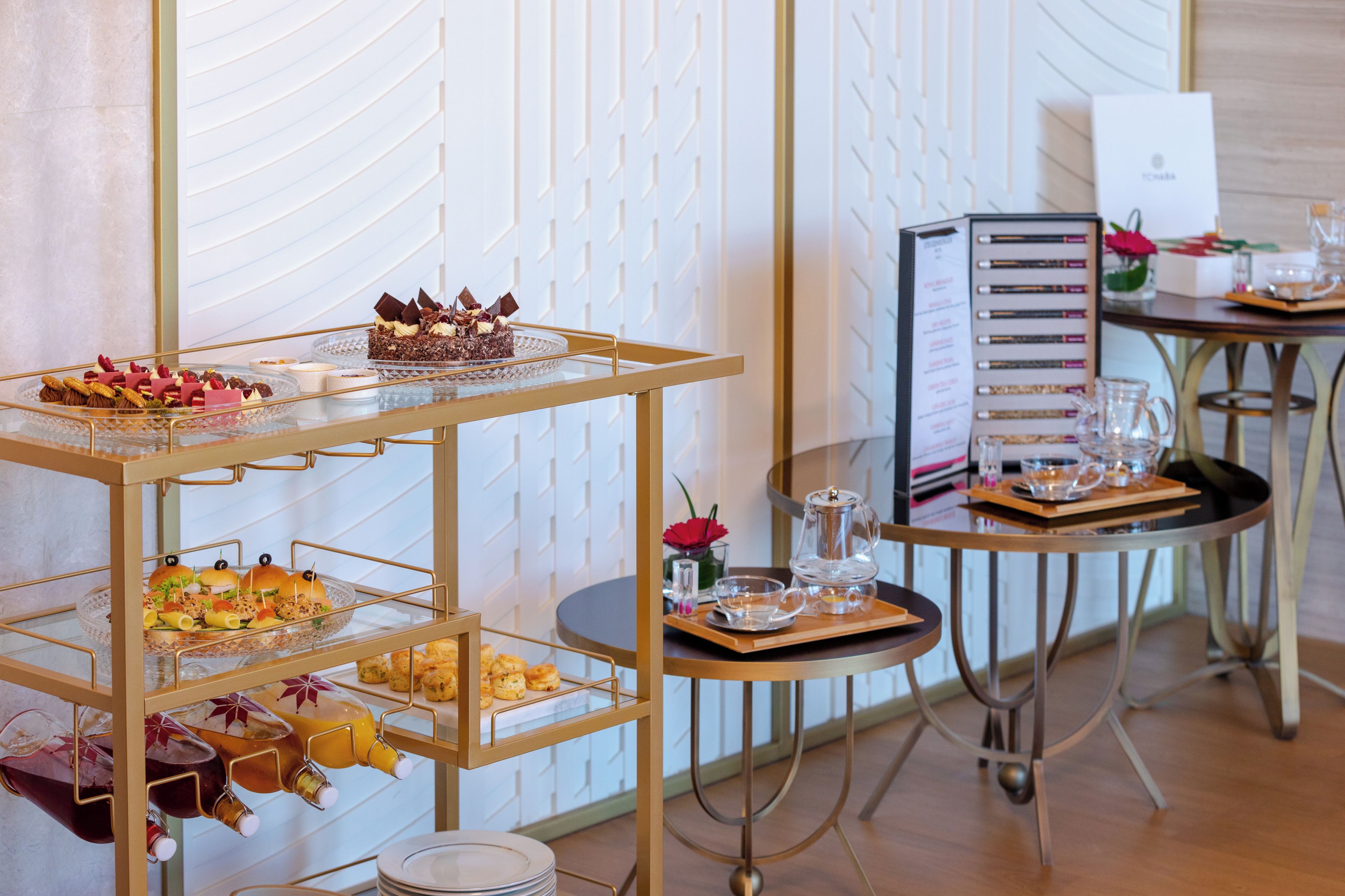 Una barra de buffet con distintos alimentos y un panel con el menú.