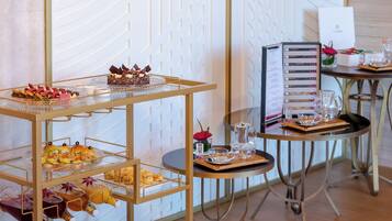 Una barra de buffet con distintos alimentos y un panel con el menú.