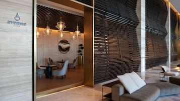 A modern interior with a dining area, a sofa, and a wall with horizontal slats.