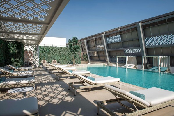 Zona de piscina con sillones de descanso y una gran alberca.