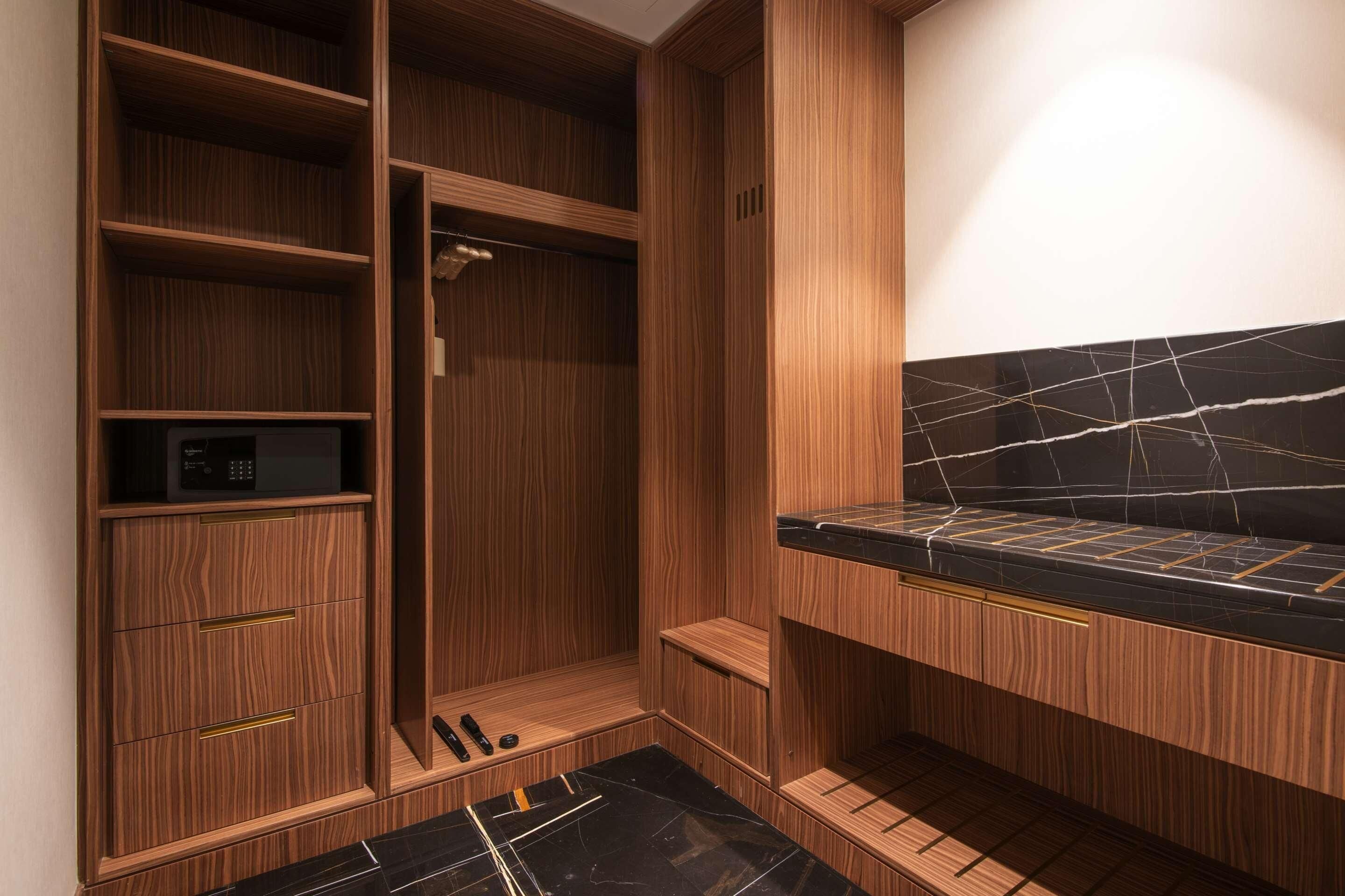 Un baño moderno con muebles de madera, encimera de mármol negro y ducha integrada.