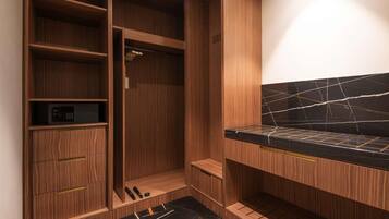 Un baño moderno con muebles de madera, encimera de mármol negro y ducha integrada.