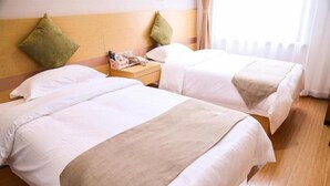 A hotel room with two beds, wooden flooring, and a nightstand with a lamp and a magazine. - Greentree Inn Nanjing Zhongshan Mausoleum Scenic Area Zhongling Street Subway Station Express Hotel (Nanjing)