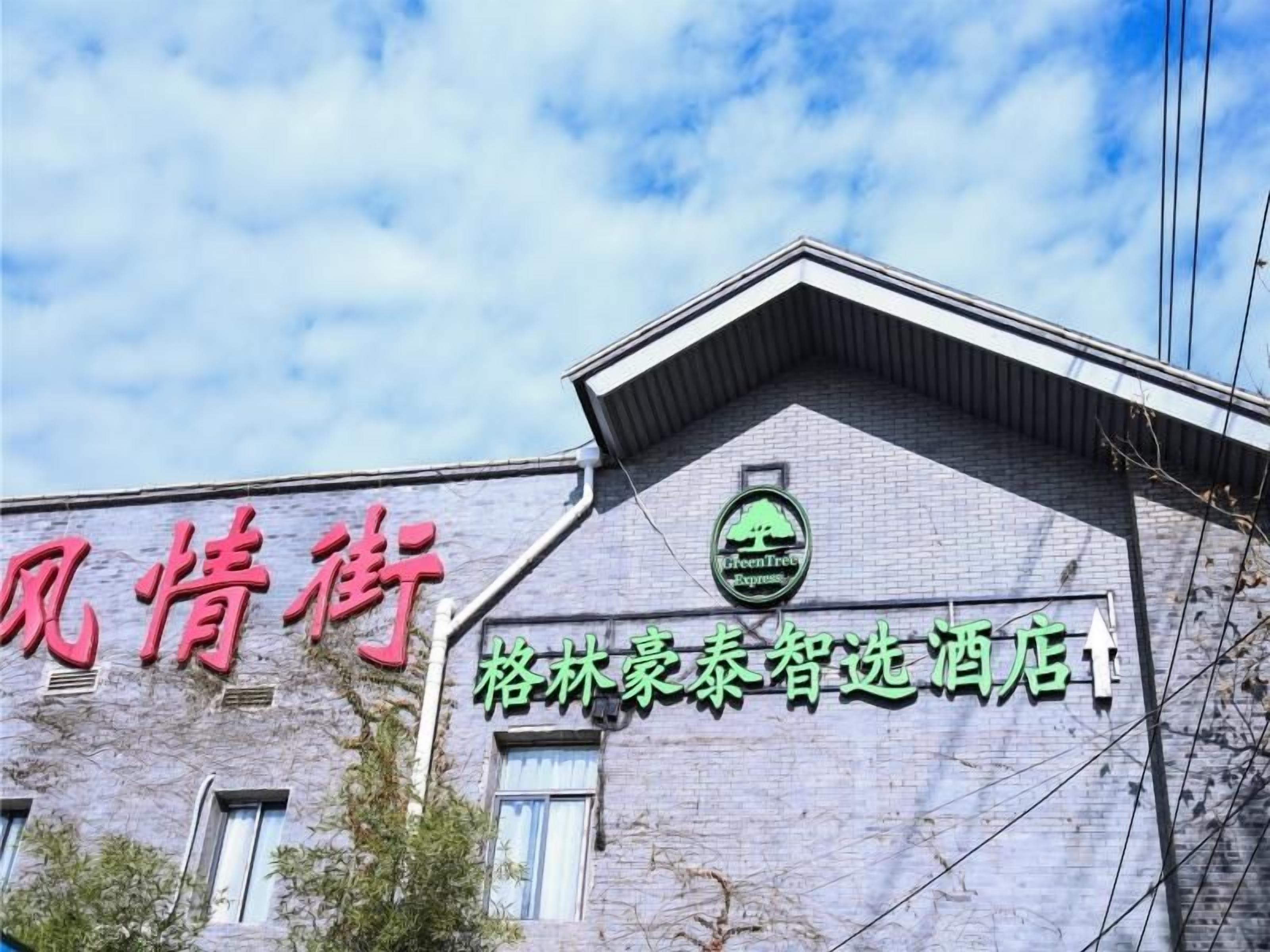 A building with a sign that reads 'Green Tree Express' and another sign with Chinese characters.